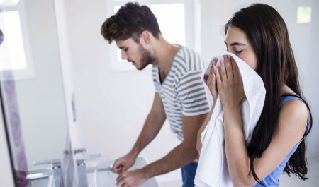 Couple in a bathroom - Woman dry her face